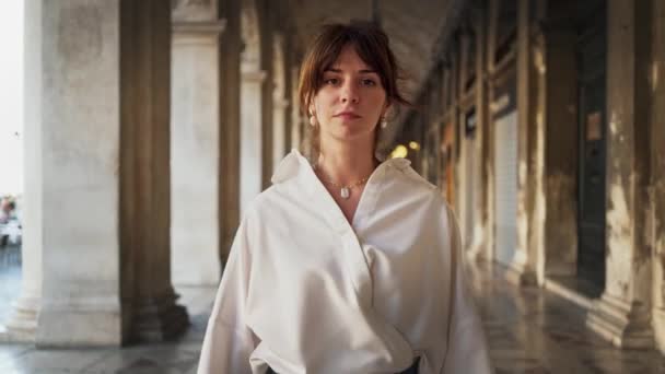 Realtids porträtt av en snygg flicka som går längs det yttre galleriet i Venedig. — Stockvideo