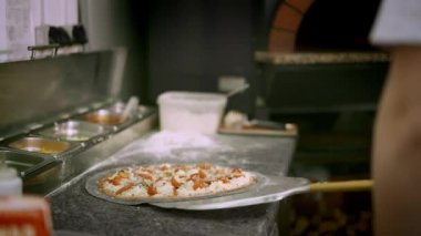 Fırında pişirmek için deniz mahsullü pizza yerken elde çekilmiş bir fotoğraf.