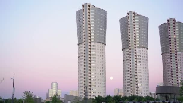 Vista panorámica de cuatro edificios residenciales modernos sobre fondo de atardecer — Vídeo de stock