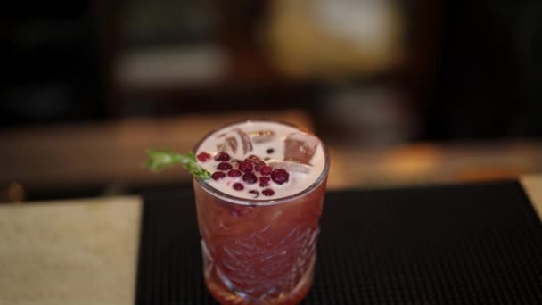 Pan macro shot van rode cocktail versierde bessen en dennen — Stockvideo