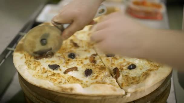 Крупним планом нарізати піцу на скибочках роликовим ножем у піцерії . — стокове відео
