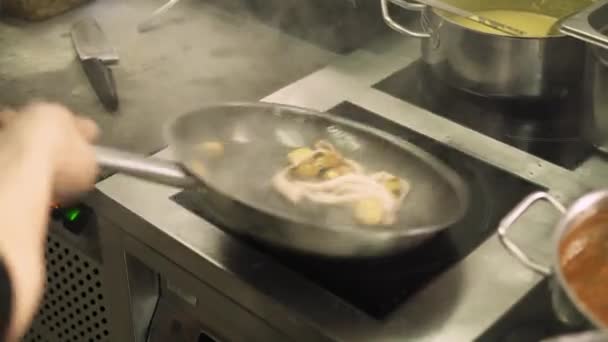 Close up of chef frying small potatoes with octopus in restaurant — Stock Video
