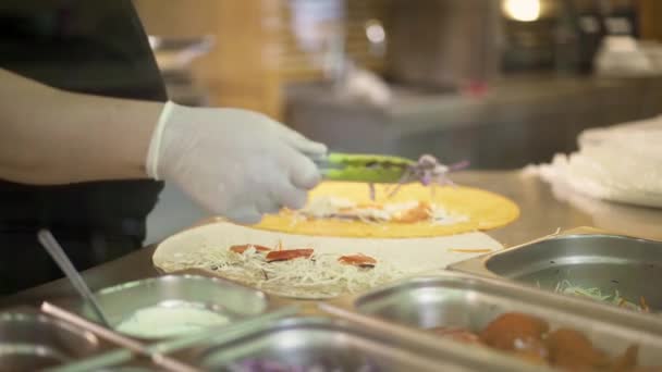 Handheld tiro de mãos chef em luvas brancas fazendo dois doadores em pita — Vídeo de Stock