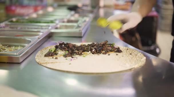 Handheld schot van chef-kok handen in witte handschoenen maken doner in pita — Stockvideo