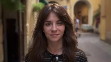 Close up of brunette smiling woman on background of european streets