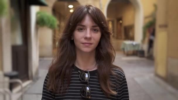 Middle shot of brunette smiling woman on background of european streets — Stockvideo