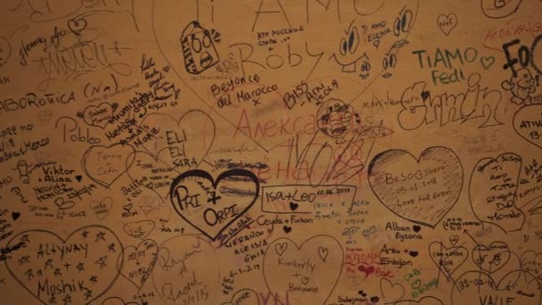 VERONA, ITALY - JUNE 2019: Close up of writings of names of lovers on the wall — Stockvideo