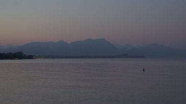 Real time wide shot of the mountain during sunset. Evening on lake Garda, Italy.