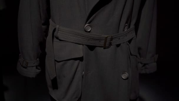 МИЛАН, ИТАЛИЯ - ИЮЛЬ 2019: Наклоните кадр с черным мужским пальто, висящим в выставочном пространстве музея "Армани Силос" — стоковое видео