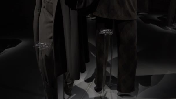 ミラノ,イタリア- 2019年7月:アルマーニ・サイロ博物館の展示スペースにぶら下がっている黒いコートのショットを傾ける — ストック動画