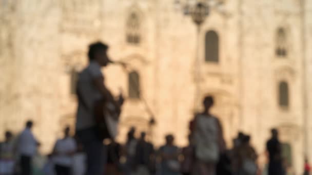 Plan flou de l'homme jouant de la guitare sur fond de Duomo di Milano — Video