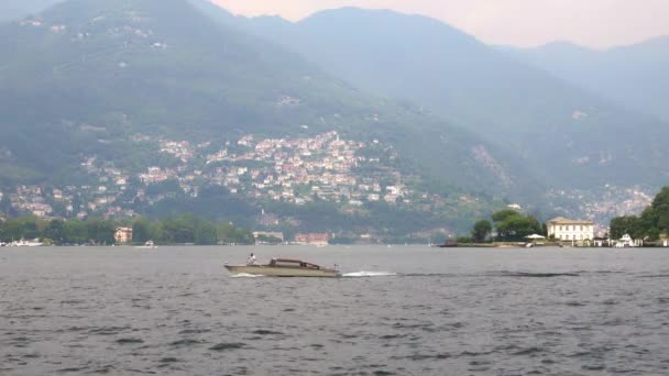 LOMBARDIA, ITALIA - JULIO 2019: Gimbal tiro de barco flotando a la izquierda en el lago Como — Vídeos de Stock