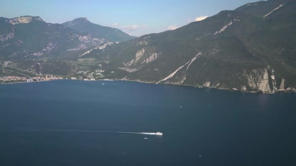 De izquierda a derecha en tiempo real amplia toma del lago de Garda y las montañas. Lago de Garda es el lago más grande de Italia . — Vídeos de Stock