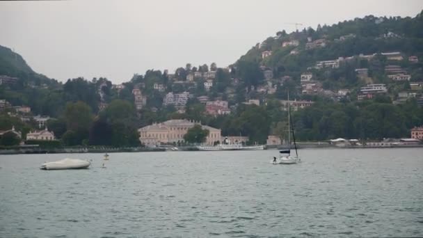 Lombardije, Italië - juli 2019: Handheld opname van Comomeer onder bewolkte hemel — Stockvideo