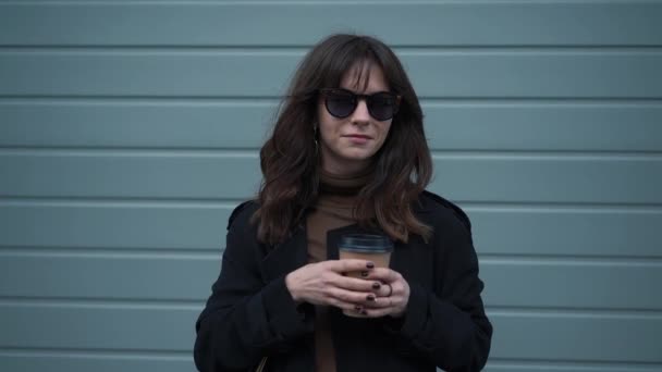 Slow motion of woman taking off sunglasses smiling with a cup of coffee — Stock Video