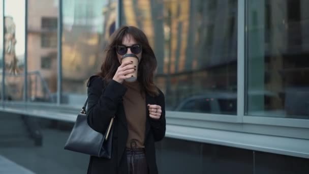 Cámara lenta de la mujer de negocios en gafas de sol con una taza de café — Vídeos de Stock