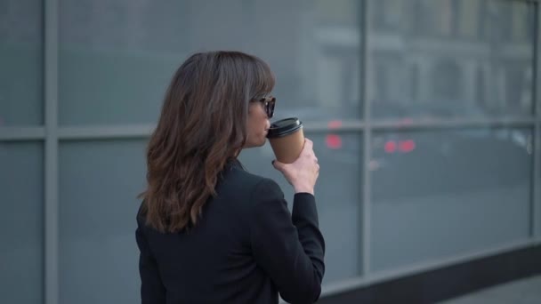 带着一杯咖啡、戴着太阳镜的商界女性慢动作简介 — 图库视频影像