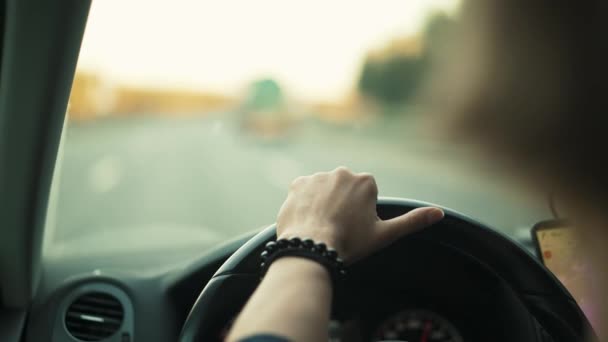 Mujer mano en un volante sin borrosa carretera de fondo — Vídeo de stock