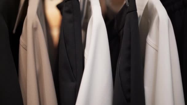 Cerca de la cacerola de izquierda a derecha de la ropa en una percha — Vídeo de stock