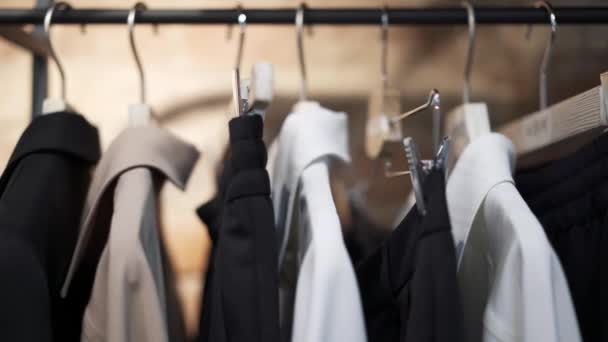 Close up pan schot links naar rechts van hangers met kleren — Stockvideo