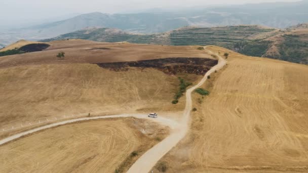 Αεροπλάνο κηφήνας από λόφους και δρόμο με αυτοκίνητο σε κίνηση — Αρχείο Βίντεο