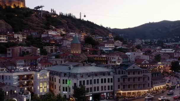 Tiflis, Georgien - Juli 2019: Luftdrohne zoomt das Tiflis-Panorama bei Sonnenuntergang heraus — Stockvideo