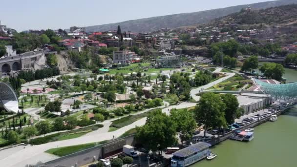 TBILISI, GEORGIA - JULIO 2019: Dron aéreo volando cerca del puente de paz en Tiflis — Vídeos de Stock