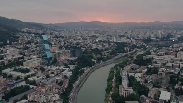 TBILISI, GEORGIE - JUILLET 2019 : Drone aérien survolant le centre de Tbilissi et la rivière Kura au coucher du soleil — Video