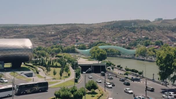 TBILISI, GEORGIA - JULIO 2019: Dron aéreo volando cerca del puente de paz en Tiflis — Vídeos de Stock