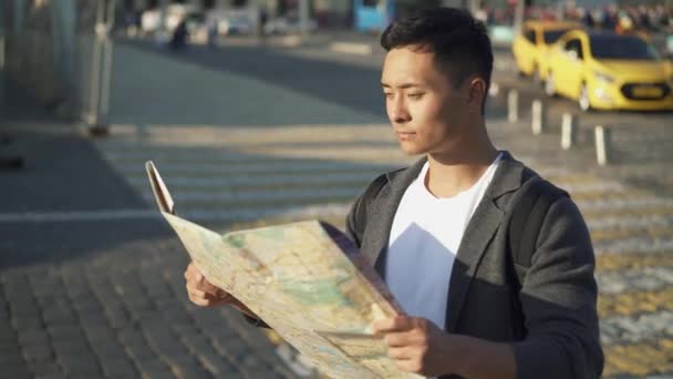 Portrait panoramique en temps réel de gauche à droite d'un jeune Asiatique regardant une carte. Moscou est la capitale et la ville la plus peuplée de Russie . — Video