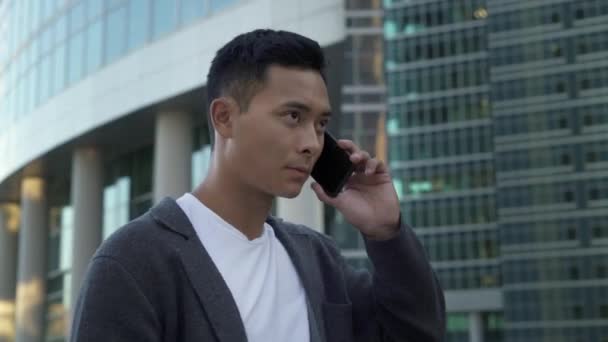 Real time shot of a young Asian guy talking on the phone in Moscow. Moscow is the capital and the most populous city in Russia. — 비디오