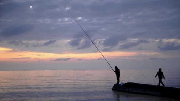 Gimbal shot of man and a child fishing on background of sea — Stock Video