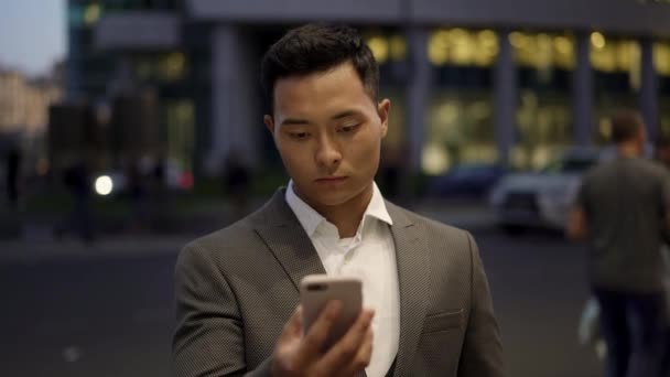 Bloqueado retrato en tiempo real de un joven empresario dirigiendo correspondencia por teléfono . — Vídeo de stock