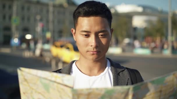 Von links nach rechts Schwenk-Echtzeitaufnahme eines jungen asiatischen Mannes beim Betrachten einer Landkarte. Touristen in Moskau. Moskau ist die Hauptstadt und die bevölkerungsreichste Stadt Russlands. — Stockvideo