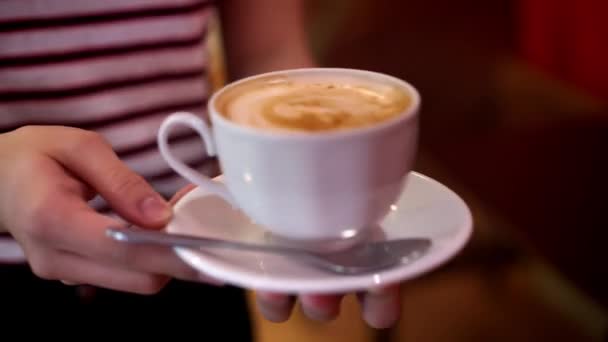 Primer plano de camarera sirviendo trayendo una taza de capuchino — Vídeo de stock