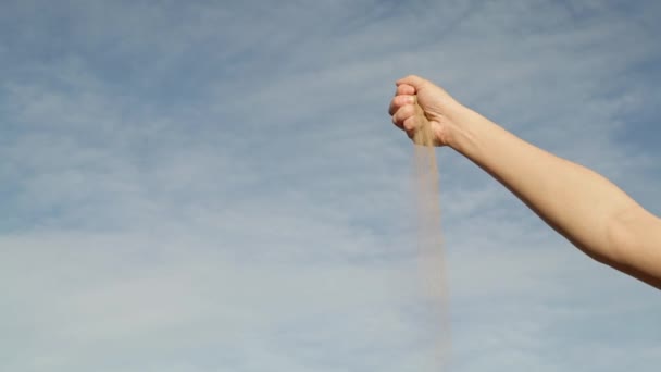 Gimbal disparo de la mano de la mujer con arena desmoronándose en el fondo del cielo — Vídeos de Stock