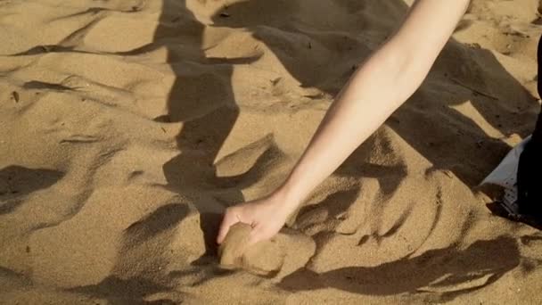 Гимбальный снимок женщины, взявшей в руку песок — стоковое видео