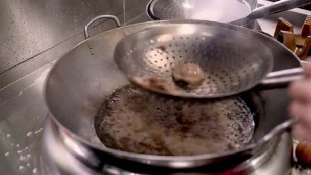 Κοντινό πλάνο χέρι του κρέατος τηγανίσματος σε βραστό λάδι — Αρχείο Βίντεο
