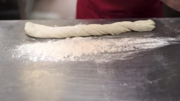 Cozinheiro rola massa em uma mesa metálica no restaurante da cozinha — Vídeo de Stock