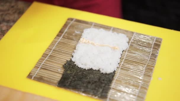 Hands in gloves making a sushi roll with eel and shrimp — 비디오