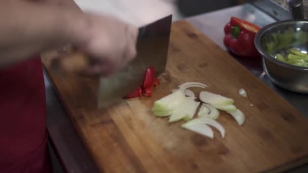 Close-up vista do cozinheiro mão picar pimentas com uma faca na tábua de corte — Vídeo de Stock