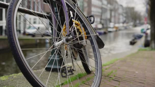 Handheld close-up tiro de roda de bicicleta estacionado perto da ponte — Vídeo de Stock