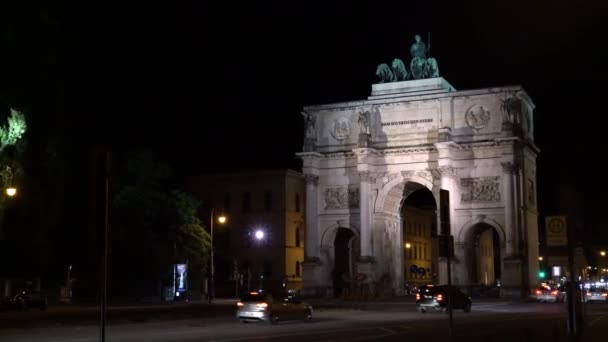 MUNICH, ALEMANHA - NOVEMBRO 10, 2018: Pan of Victory Triumphal Arch of the Bavarian Army at night, Munique, Alemanha. Tráfego noturno em Munique perto Victory Arch . — Vídeo de Stock