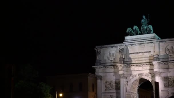 MUNICH, ALEMANHA - NOVEMBRO 10, 2018: Pan of Victory Triumphal Arch of the Bavarian Army at night, Munique, Alemanha. Tráfego noturno em Munique perto Victory Arch . — Vídeo de Stock