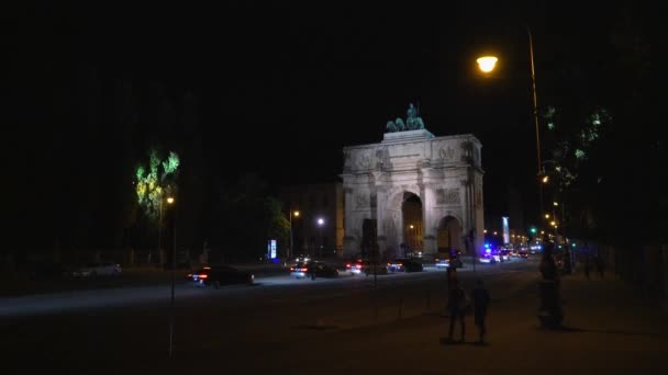 MUNICH, ALEMANIA - 10 DE NOVIEMBRE DE 2018: Bloqueo de la victoria Arco triunfal del ejército bávaro por la noche, Munich, Alemania. Tráfico nocturno en Munich cerca de Victory Arch . — Vídeos de Stock