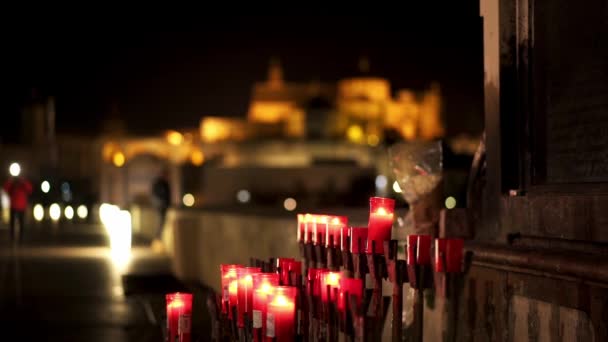 Kaarsen onder standbeeld van de aartsengel van St. Gabriel op de Romeinse brug. — Stockvideo