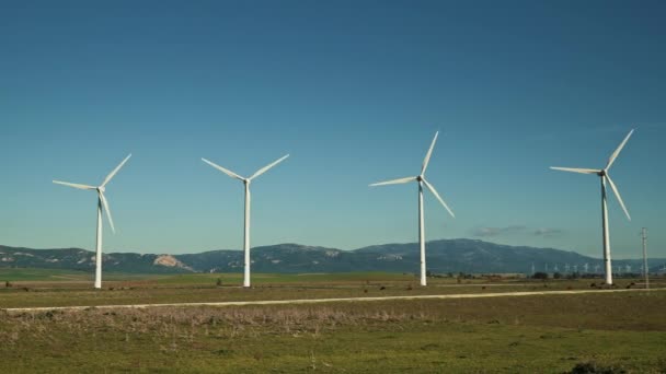 Pan shot van windmolens op de achtergrond van bergen in Spanje — Stockvideo