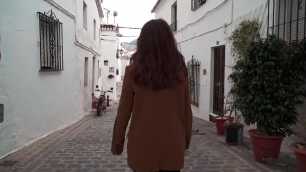 Zoom en gimbal de mujer caminando en estrecha calle blanca en Mijas — Vídeos de Stock