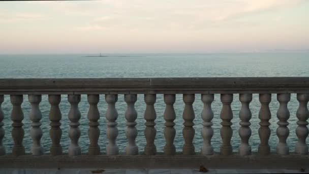 Гимбальный снимок парапета в Кадисе с морем и крошечным островом вдали — стоковое видео