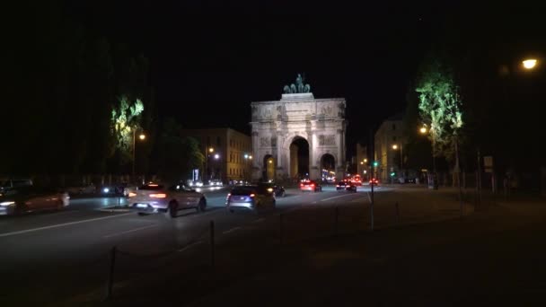 München, Tyskland - 10 november 2018: Nedstängning av den bayerska arméns triumfbåge på natten, München, Tyskland. Natt trafik i München i närheten Victory Arch. — Stockvideo